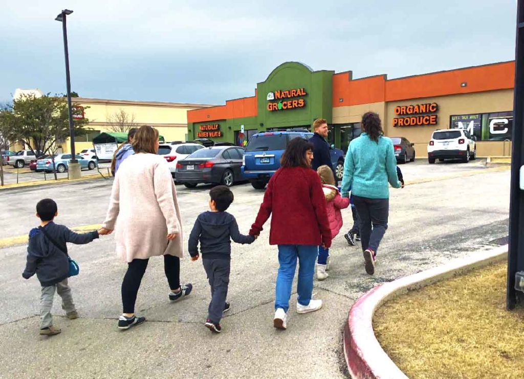 A group of ABA therapy technicians walk with children with autism to a grocery store for life skills training