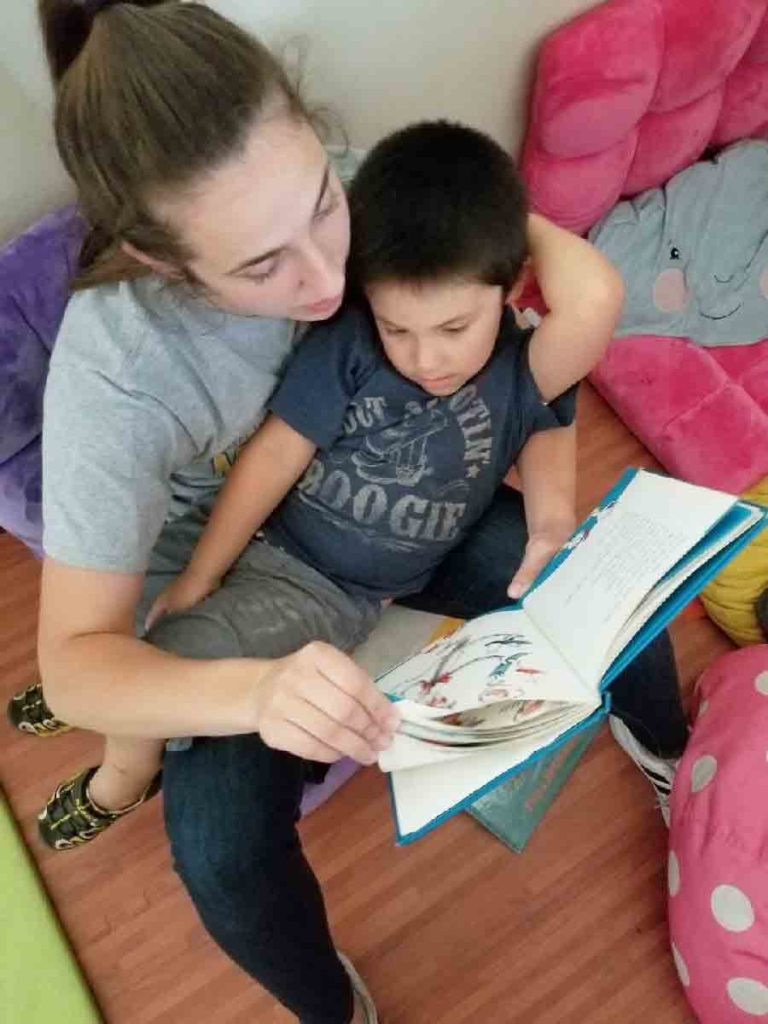 A therapist works on reading with a child with autism for speech therapy