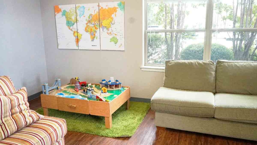 Play area with couches and a train table at Bright Mosaic