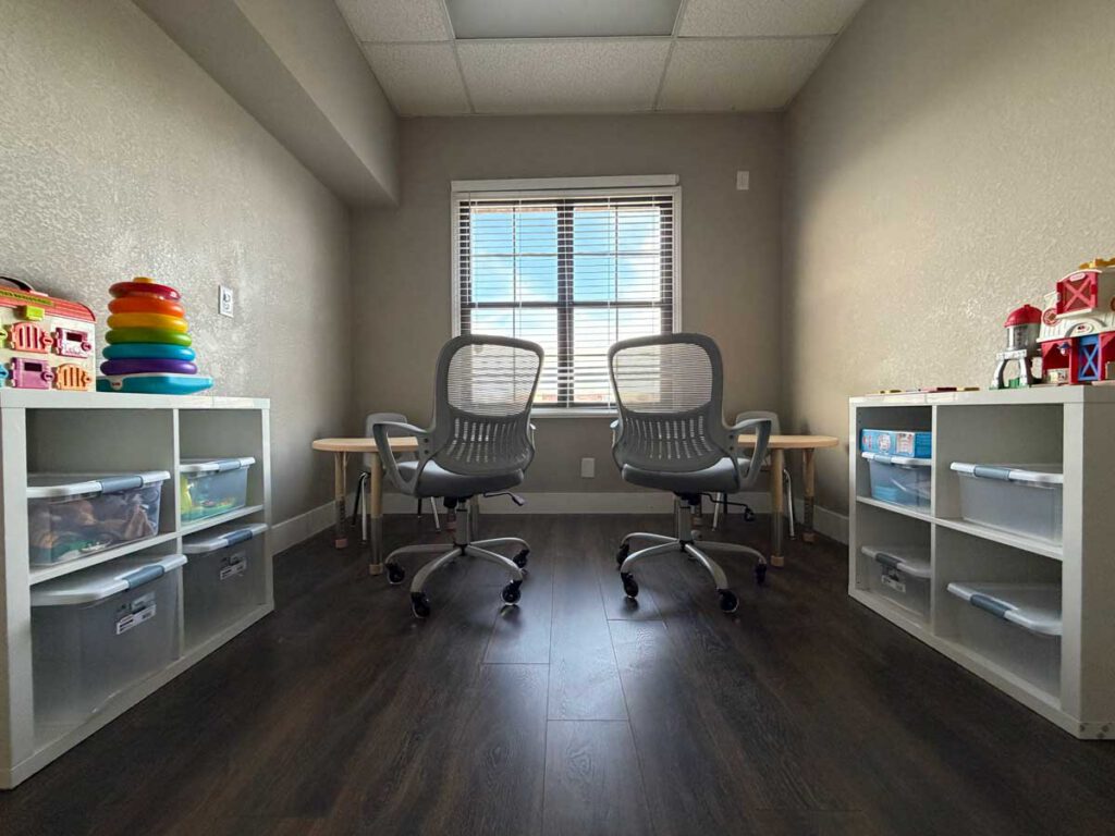 A dedicated DTT room for one-on-one ABA therapy sessions at Bright Mosaic Sherman, showing organized workstations and sensory toys.