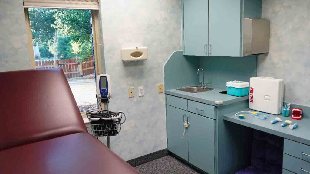 Mock medical play room at Bright Mosaic in Denton with an exam table, blood pressure monitor, and medical play kits to help children with autism practice for doctor visits.