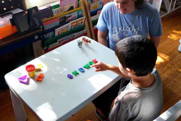 A young boy practicing communication skills during a one on one session of ABA therapy for children with autism.