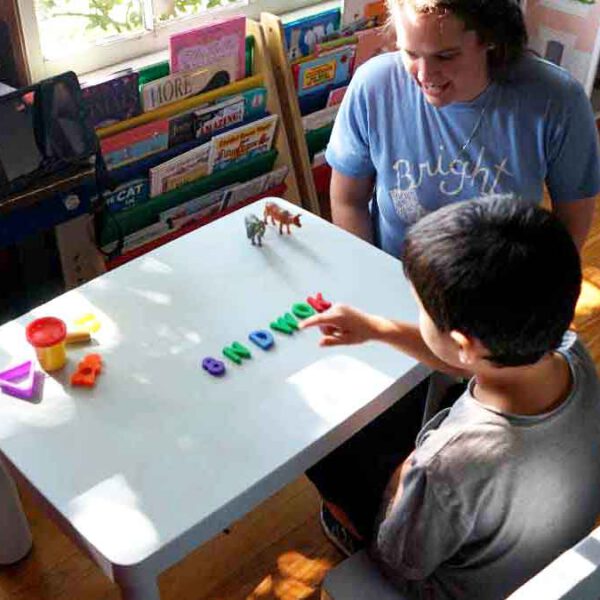 A young boy practicing communication skills during a one on one session of ABA therapy for children with autism.